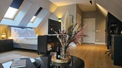 a living room with a bed and a table with a vase at Guest Room Utrecht in Utrecht