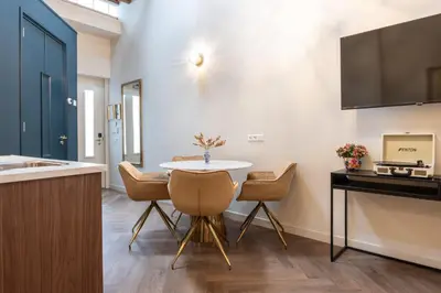 a small kitchen with a table and chairs in a room at Grapèlli Boutique Hotel in Alkmaar