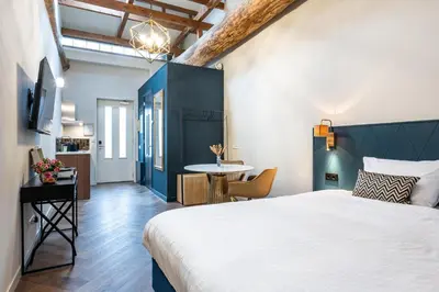 a bedroom with a large bed and a table at Grapèlli Boutique Hotel in Alkmaar