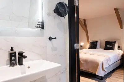 a bathroom with a sink and a bed in a room at Limehome Amsterdam Leidsekruisstraat in Amsterdam