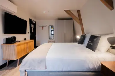 a bedroom with a large bed and a flat screen tv at Limehome Amsterdam Leidsekruisstraat in Amsterdam