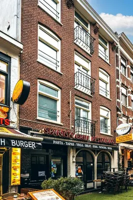 a brick building with a sign on the side of it at Limehome Amsterdam Leidsekruisstraat in Amsterdam