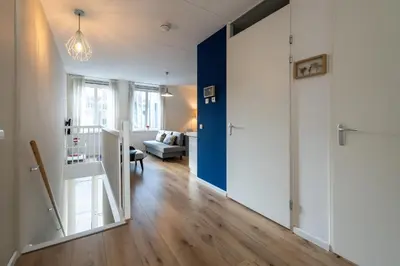 a hallway with a blue door and a living room at Aparthotel North Spacious Suite for 6 Guests in Amsterdam