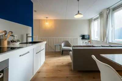 a kitchen and living room with a couch and a table at Aparthotel North Spacious Suite for 6 Guests in Amsterdam