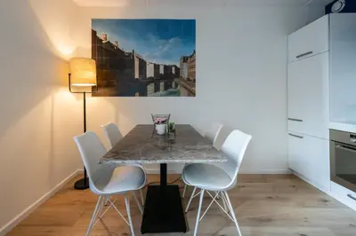 a dining room with a table and white chairs at Aparthotel North Spacious Suite for 6 Guests in Amsterdam