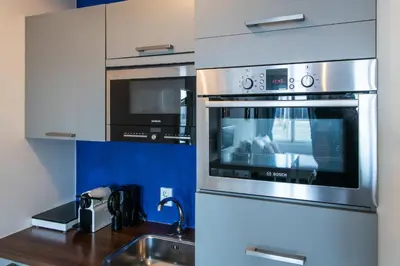 a kitchen with a stainless steel oven and a sink at Aparthotel North Spacious Studio for two in Amsterdam