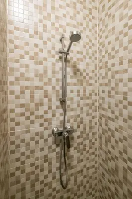 a shower with a hose in a tiled bathroom at Aparthotel North Studio With Patio For 2 in Amsterdam
