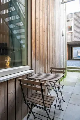 a wooden table and chairs next to a window at Aparthotel North Studio With Patio For 2 in Amsterdam