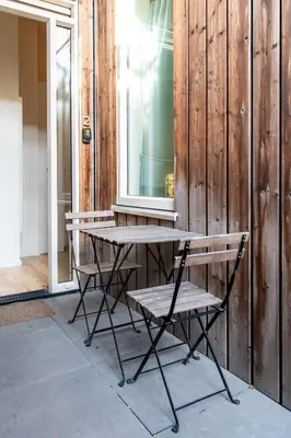 a wooden table and a bench next to a building at Aparthotel North Studio With Patio For 2 in Amsterdam