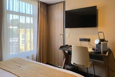 a hotel room with a desk with a computer and a window at XO Hotel Inner in Amsterdam