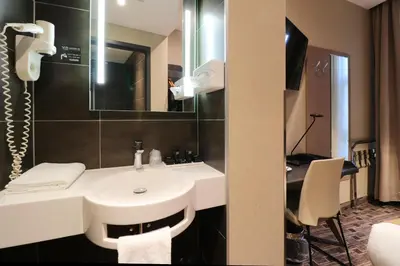 a bathroom with a sink and a mirror and a desk at XO Hotel Inner in Amsterdam