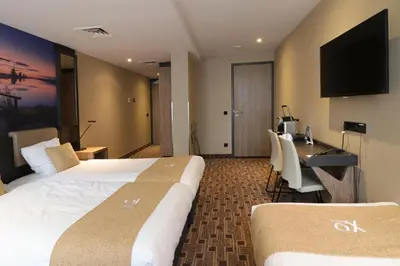 a hotel room with two beds and a desk at XO Hotel Inner in Amsterdam
