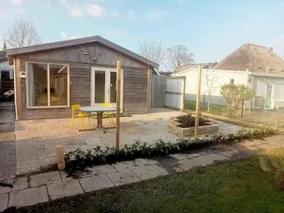 a small house with a table in a yard at tiny house nabij de kust in Dirkshorn