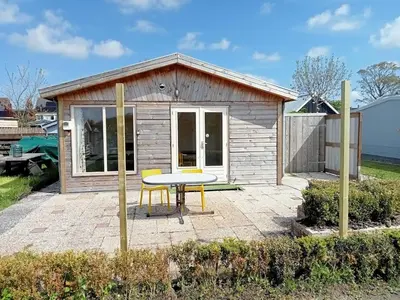 a small shed with a table and chairs on a patio at tiny house nabij de kust in Dirkshorn