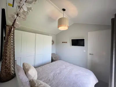 a bedroom with a bed and a vase with flowers at NEW - Waterhouse Linada on a lake near Amsterdam in Vinkeveen
