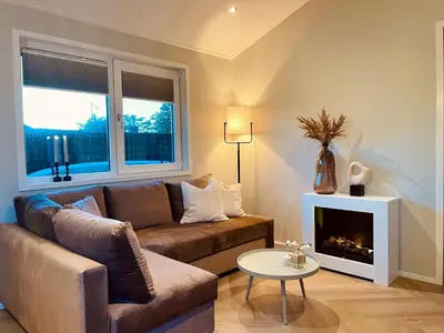 a living room with a couch and a fireplace at NEW - Waterhouse Linada on a lake near Amsterdam in Vinkeveen