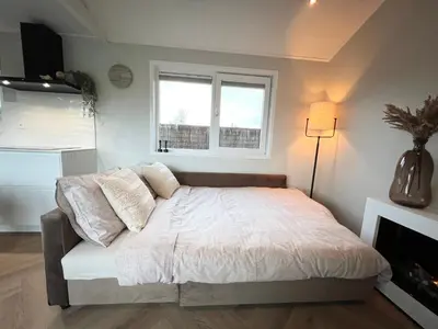 a bedroom with a bed and a window at NEW - Waterhouse Linada on a lake near Amsterdam in Vinkeveen