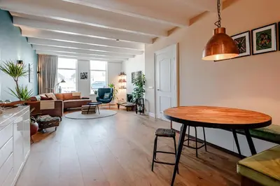 a kitchen and living room with a table and a couch at Luxurious Family Home Amstelveen in Amstelveen