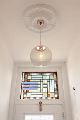 a chandelier hanging over a door with a stained glass window at Luxurious Family Home Amstelveen in Amstelveen
