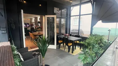 a dining room with a table and some plants at Seastreet Robert in Zandvoort