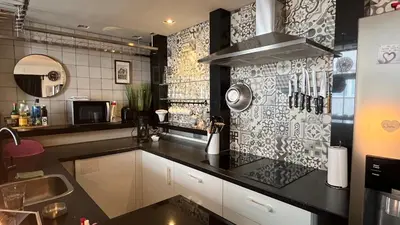 a kitchen with a black counter top and a sink at Seastreet Robert in Zandvoort