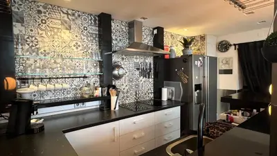 a kitchen with a black counter and a refrigerator at Seastreet Robert in Zandvoort