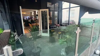 a house with a glass balcony with a living room at Seastreet Robert in Zandvoort