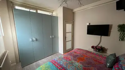 a bedroom with a bed and a flat screen tv at Seastreet Robert in Zandvoort