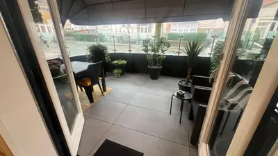 a balcony with a table and potted plants at Seastreet Robert in Zandvoort