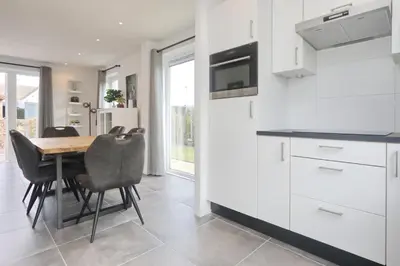 a kitchen and dining room with a table and chairs at Chateau Noordwijk in Noordwijk