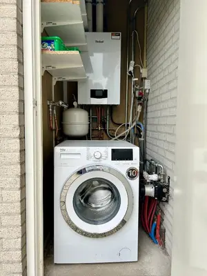 a washing machine in a room with a wall at Chateau Noordwijk in Noordwijk