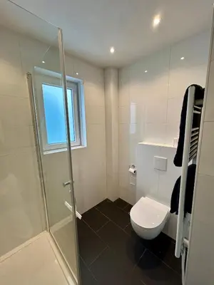 a bathroom with a toilet and a glass shower at Chateau Noordwijk in Noordwijk