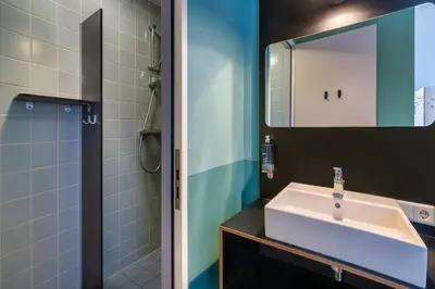 a bathroom with a sink and a shower at Stayokay Hostel Haarlem in Haarlem