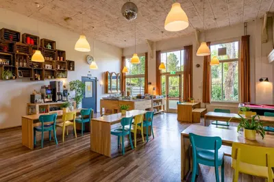 a restaurant with tables and chairs and windows at Stayokay Hostel Haarlem in Haarlem