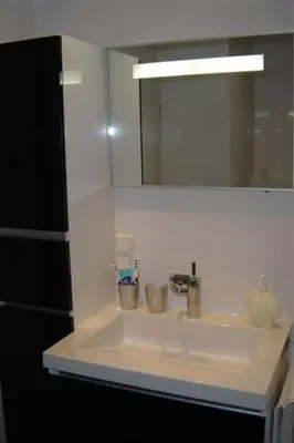 a bathroom counter with a sink and a mirror at Sterflat 87 in Egmond aan Zee