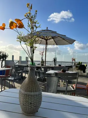 a vase sitting on a table with flowers in it at Sterflat 97 in Egmond aan Zee