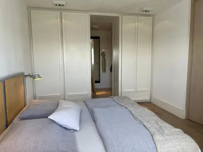 a large bed in a room with white cabinets at Sterflat 97 in Egmond aan Zee