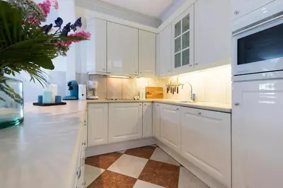 a white kitchen with white cabinets and a sink at Sterflat 99 in Egmond aan Zee