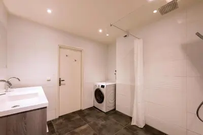 a bathroom with a washing machine and a washer at Sterflat 99 in Egmond aan Zee