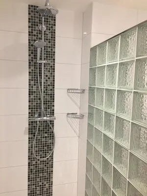 a bathroom with a shower with glass tiles at Sterflat 103 in Egmond aan Zee