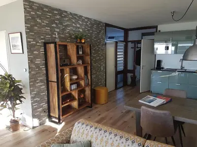 a living room with a table and a kitchen at Sterflat 103 in Egmond aan Zee