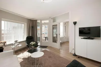 a living room with a couch and a tv at Sterflat 107 in Egmond aan Zee