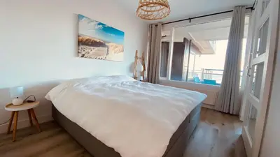 a bedroom with a large bed and a window at Sterflat 119 in Egmond aan Zee