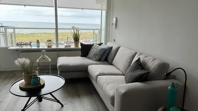 a living room with a couch and a table at Sterflat 119 in Egmond aan Zee