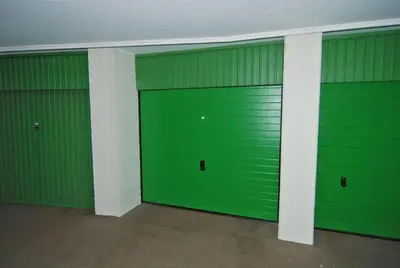three green garage doors in an empty building at Sterflat 129 in Egmond aan Zee