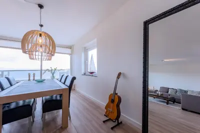 a dining room with a table and a guitar at Sterflat 147 in Egmond aan Zee