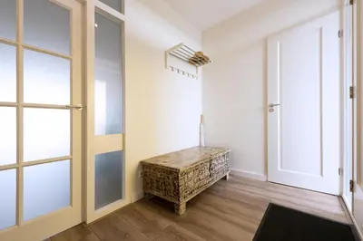 a hallway with a wooden table and a door at Sterflat 147 in Egmond aan Zee
