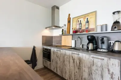 a kitchen with a sink and a counter top at Sterflat 147 in Egmond aan Zee