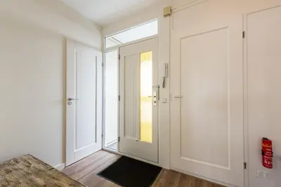 an empty hallway with a door and a window at Sterflat 147 in Egmond aan Zee