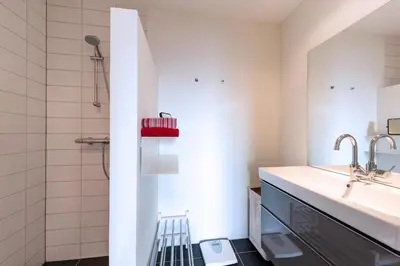 a bathroom with a sink and a shower at Sterflat 147 in Egmond aan Zee